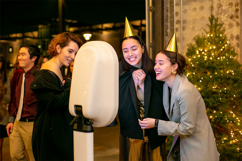 Friends laughing at a holiday party photo booth