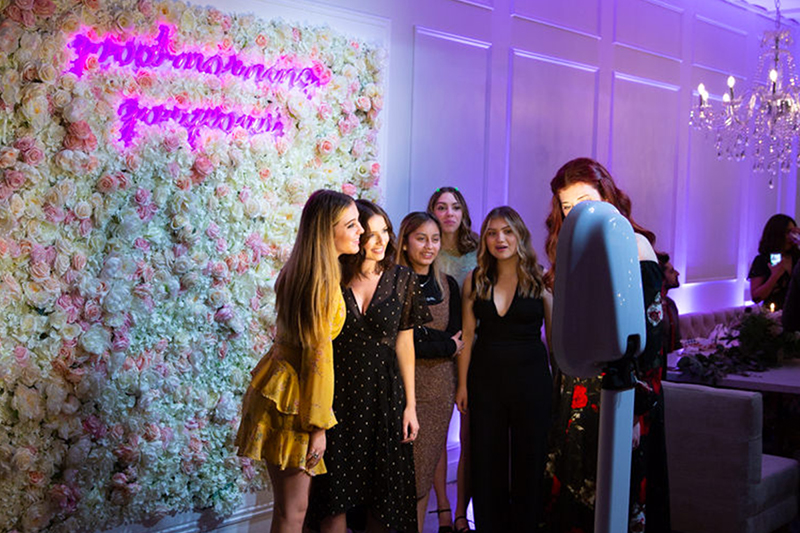 Friends posing in front of a flower wall